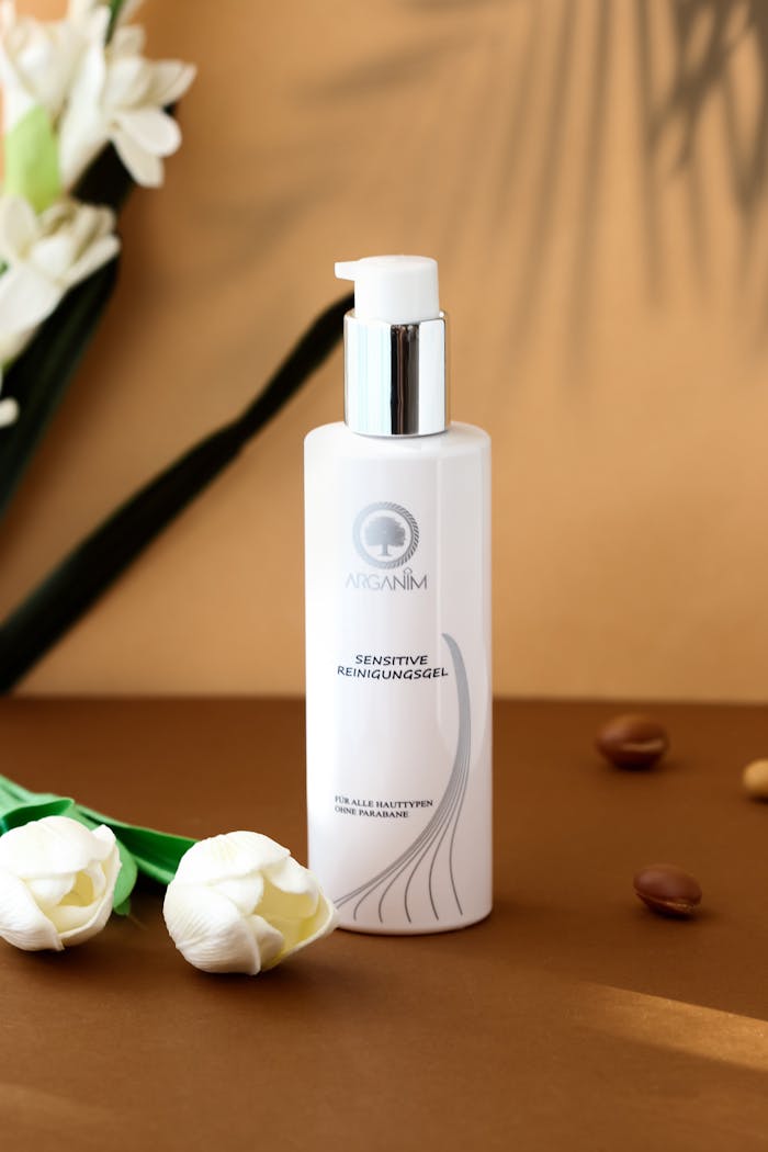 services-02 Sophisticated still life of a cosmetic product with white tulips on a beige background.