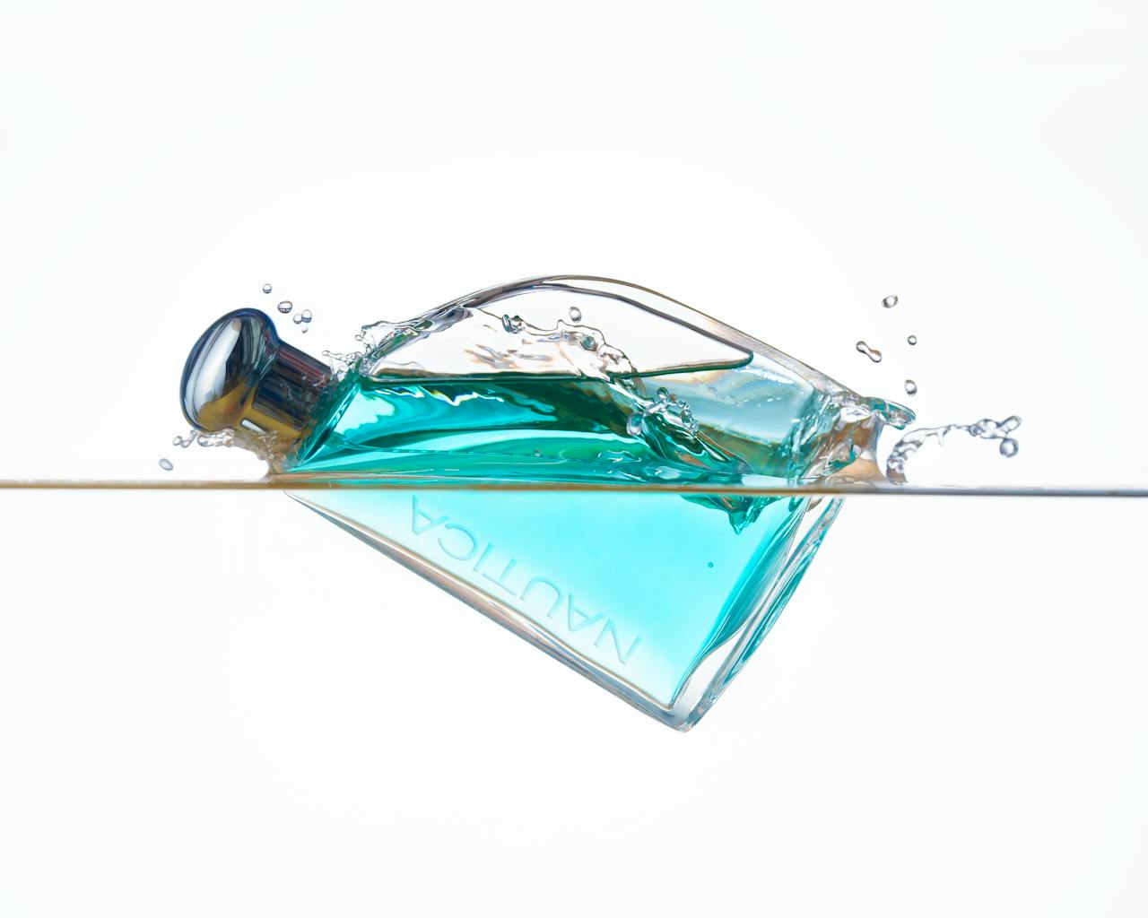 services-05 A luxurious perfume bottle immersed in water, creating dynamic splashes and reflections.